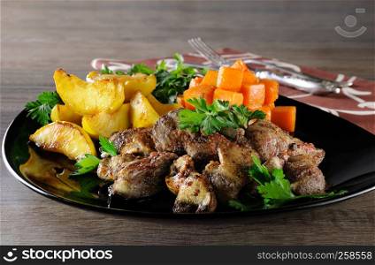 Fried chicken liver with vegetable garnish, baked pumpkin and apple.