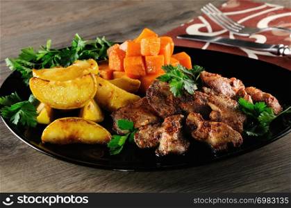 Fried chicken liver with vegetable garnish, baked pumpkin and apple.