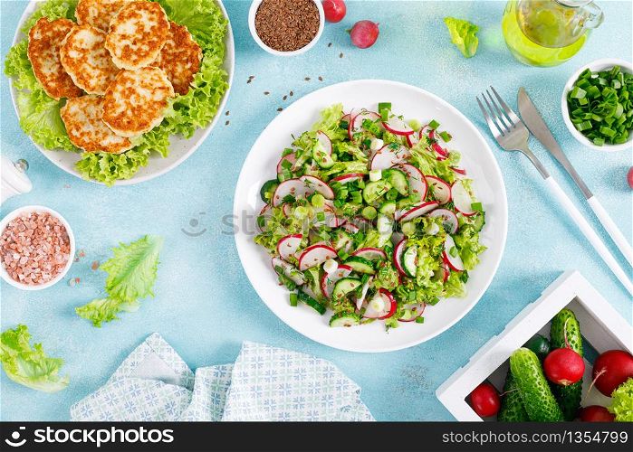 Fried chicken meat cutlets, fresh vegetable salad with radish, lettuce, green onion, dill and cucumber for lunch