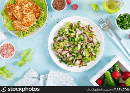 Fried chicken meat cutlets, fresh vegetable salad with radish, lettuce, green onion, dill and cucumber for lunch