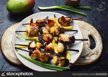 Fried chicken meat on wooden skewers. Kebabs with mango. Chicken breast kebab with mango