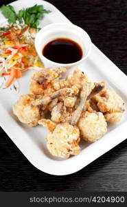 Fried chicken wings garnished with fresh vegetables with Teriyaki sauce