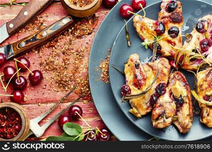 Fried chicken wings in spicy cherry sauce.Grilled chicken, fast food.. Chicken wings with cherries.