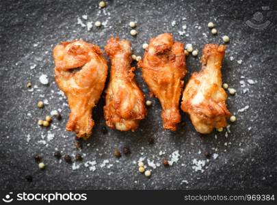 Fried chicken wings on black plate with salt herbs and spices , top view / Baked chicken wings BBQ or wings crispy