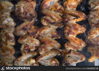 fried chicken wings on the grill in the open air. fried chicken wings on the grill