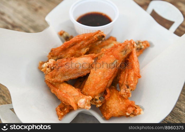 fried chicken wings with sauce thai food on wooden table food background - top view