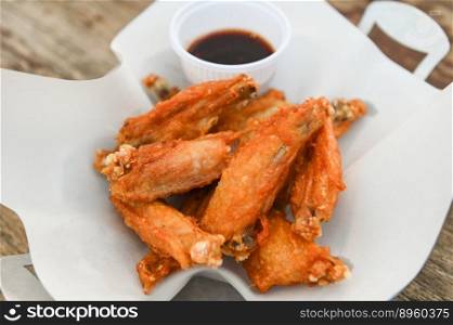 fried chicken wings with sauce thai food on wooden table food background - top view