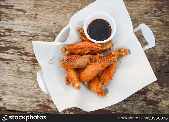fried chicken wings with sauce thai food on wooden table food background - top view  