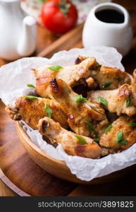 Fried chicken wings with sauces in wooden bowl, top view