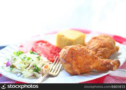 Fried chicken with coleslaw, tomatoes and cornbread with room for text