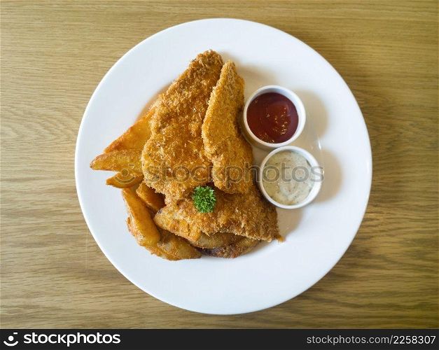 Fried chickens with dips on wooden table 