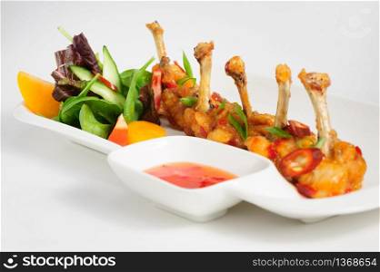 fried chilli chicken wings with vegetable salad and hot sauce. fried chilli chicken wings