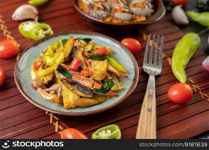 Fried crab with curry powder in a plate with bell peppers and tomatoes.