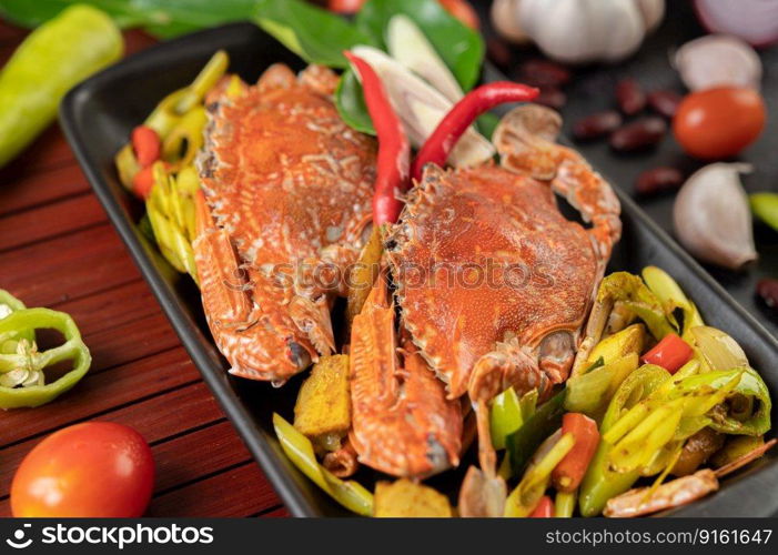 Fried crab with curry powder in a plate with bell peppers and tomatoes.