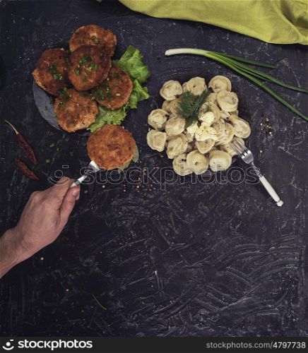 Fried cutlets and russian pelmeni on black background. Fried cutlets and russian pelmeni on black background. Food set. Top view.