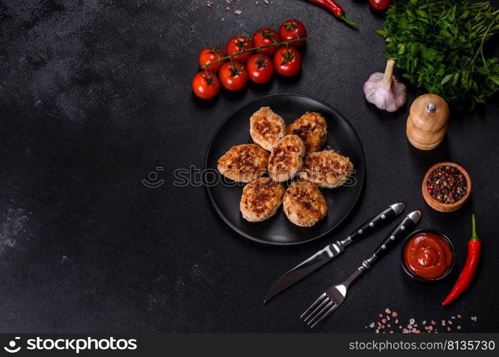 Fried cutlets from minced meat in frying pan and spices on a dark concrete background. Delicious fresh fried minced meat patties on a dark concrete background