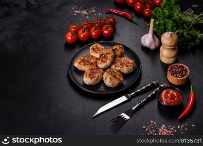 Fried cutlets from minced meat in frying pan and spices on a dark concrete background. Delicious fresh fried minced meat patties on a dark concrete background