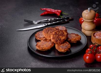 Fried cutlets of minced fish on serving board. View from above. Fish cakes. Fish patties. Fried cutlets of minced fish on a black plate