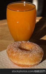 Fried Donut in White Dish and Glass of Apricot Juice