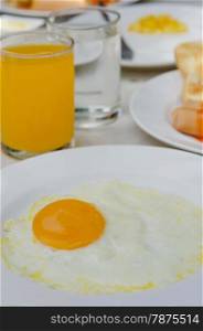 fried egg and juice. close up fried eggs on a white plate with orange juice for breakfast