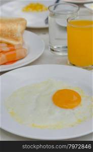 fried egg and juice. close up fried eggs on a white plate with orange juice for breakfast