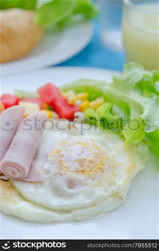 fried egg , ham , sausage and fresh vegetable on dish