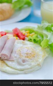 fried egg , ham , sausage and fresh vegetable on dish