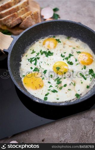 Fried Egg in cast iron frying pan on black induction hob.. Fried Egg in cast iron frying pan on black induction hob