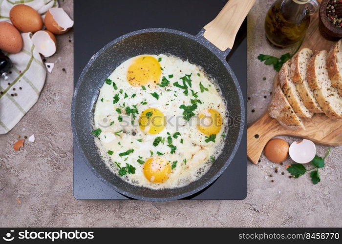 Fried Egg in cast iron frying pan on black induction hob.. Fried Egg in cast iron frying pan on black induction hob