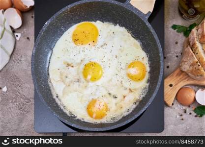 Fried Egg in cast iron frying pan on black induction hob.. Fried Egg in cast iron frying pan on black induction hob