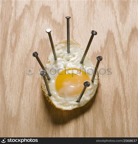 Fried egg nailed to wood.