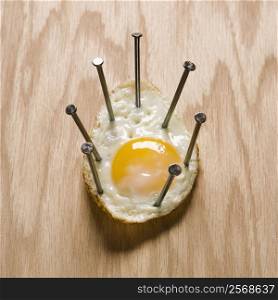 Fried egg nailed to wood.