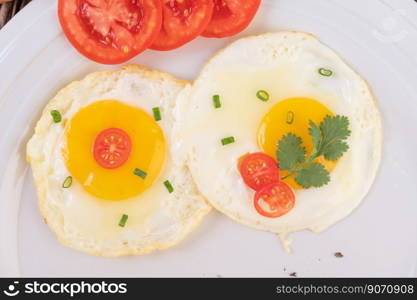 Fried egg on a white plate with sliced   Spring onion and sliced   tomatoes