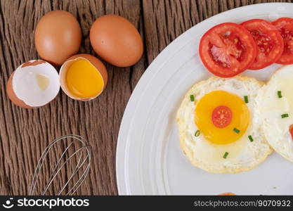 Fried egg on a white plate with sliced   Spring onion and sliced   tomatoes