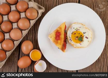 Fried egg on a white plate with toast, sliced   Spring onion and sliced   tomatoes