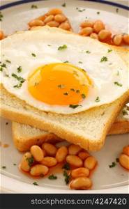 Fried egg on toast parsley garnish and baked beans.