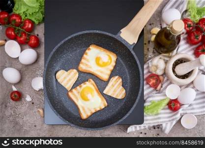 Fried egg Toasts with heart shaped holes on frying pan.. Fried egg Toasts with heart shaped holes on frying pan
