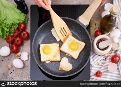 Fried egg Toasts with heart shaped holes on frying pan.. Fried egg Toasts with heart shaped holes on frying pan