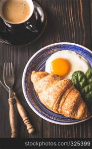 Fried egg with croissant and a cup of coffee