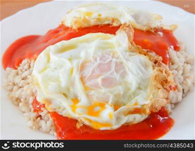Fried egg with rice overcooked and tomato sauce