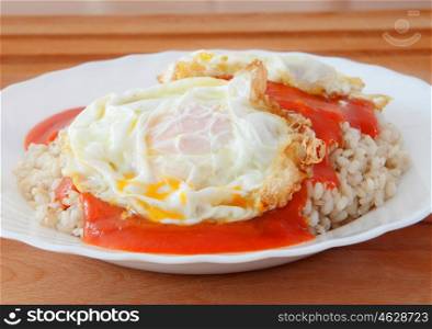 Fried egg with rice overcooked and tomato sauce