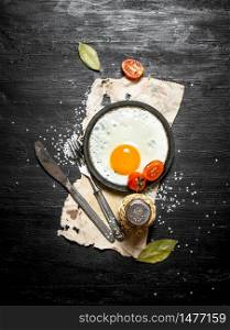 Fried egg with spices. On a black wooden background.. Fried egg with spices. On black wooden background.