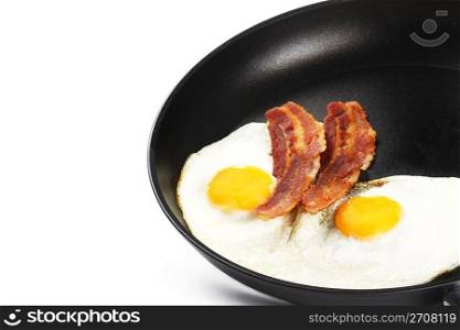 fried eggs and bacon in a pan. two fried eggs and two pieces of bacon in a pan on white background