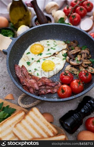 Fried eggs and bacon on a pan at domestic kitchen.. Fried eggs and bacon on a pan at domestic kitchen