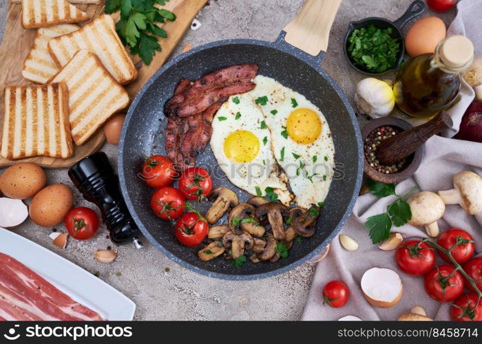 Fried eggs and bacon on a pan at domestic kitchen.. Fried eggs and bacon on a pan at domestic kitchen