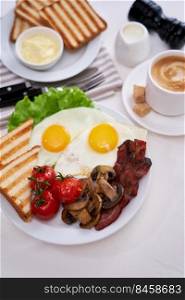 Fried eggs, bacon, tomato, toasted bread in white ceramic plate and cup of coffee.. Fried eggs, bacon, tomato, toasted bread in white ceramic plate and cup of coffee