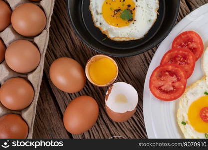 Fried eggs in a frying pan and raw eggs, organic food for good hea<h, high in protein.