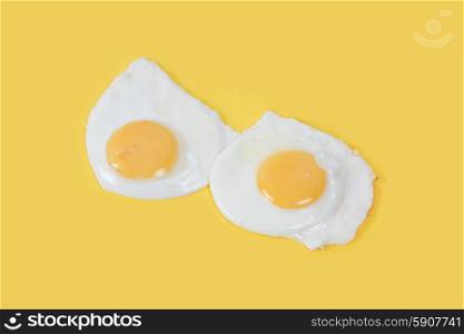 Fried eggs on yellow background. Fried eggs