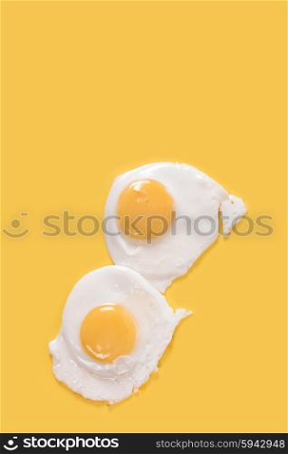 Fried eggs on yellow. Fried eggs on yellow background