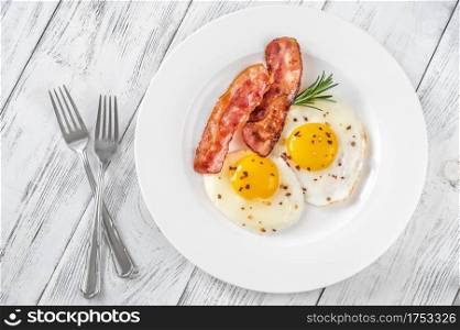Fried eggs with bacon rashers  on the white plate